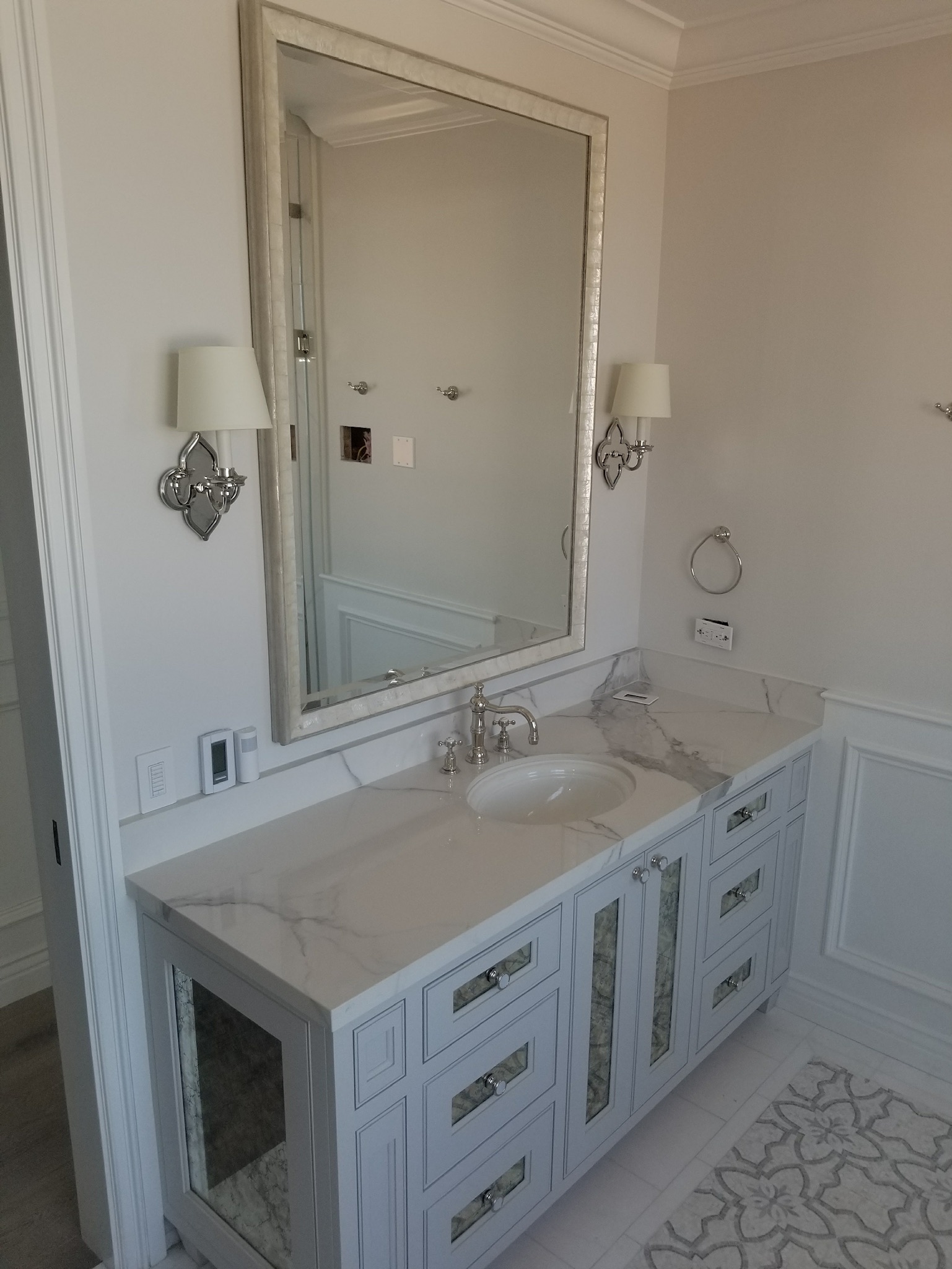 Custom white vanity with marble countertop and framed mirror by RMK Builders